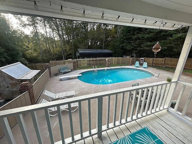 view of pool featuring a diving board, a fenced in pool, a fenced backyard, and a patio area