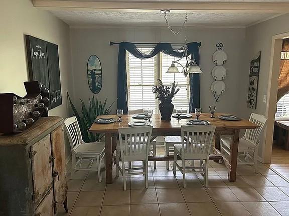 dining room featuring ornamental molding and light tile patterned flooring