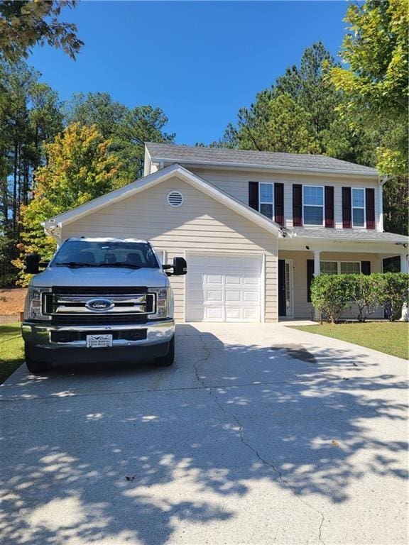 view of front of property featuring concrete driveway and an attached garage