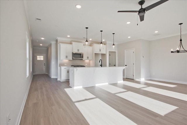 101 Priestwood Ln, Acworth, GA 30102 - kitchen with stainless steel microwave, baseboards, a center island with sink, white cabinets, and ceiling fan