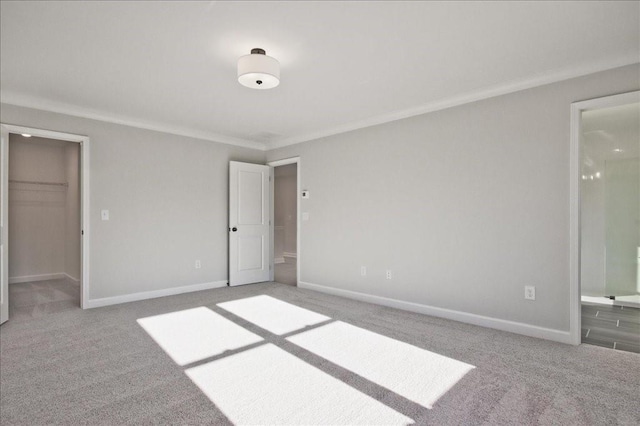 101 Priestwood Ln, Acworth, GA 30102 - unfurnished bedroom featuring carpet flooring, a walk in closet, baseboards, ensuite bathroom, and ornamental molding