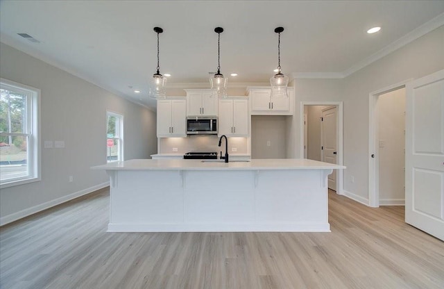 101 Priestwood Ln, Acworth, GA 30102 - kitchen featuring stainless steel microwave, a sink, light countertops, ornamental molding, and light wood finished floors