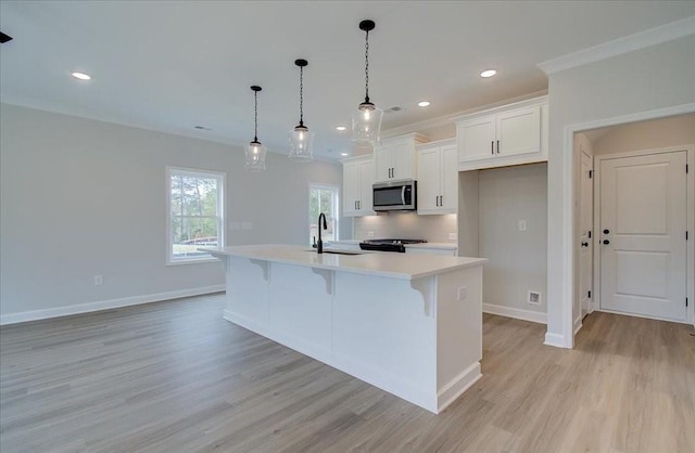 101 Priestwood Ln, Acworth, GA 30102 - kitchen with stainless steel microwave, a sink, light countertops, white cabinetry, and light wood-type flooring