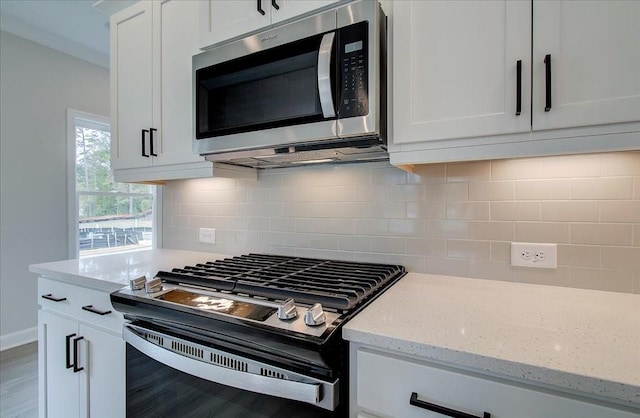 101 Priestwood Ln, Acworth, GA 30102 - kitchen with stainless steel microwave, range with gas stovetop, white cabinetry, and wood finished floors