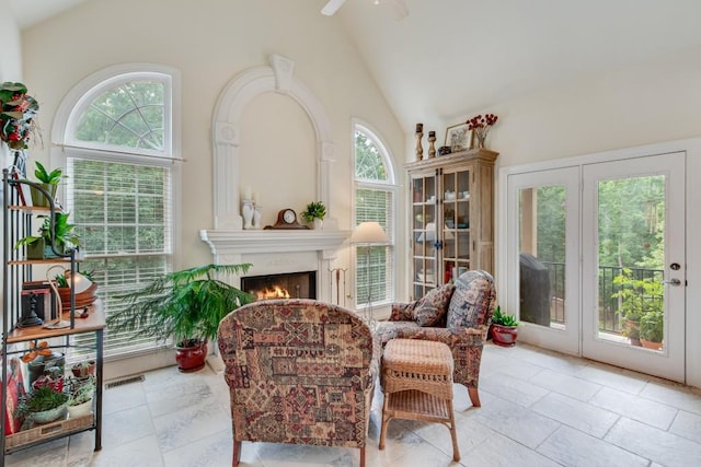 5359 Point S Dr, Gainesville, GA 30504 - sitting room featuring a warm lit fireplace, ceiling fan, and high vaulted ceiling
