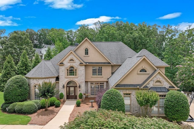 5359 Point S Dr, Gainesville, GA 30504 - view of front facade featuring stucco siding, brick siding, a shingled roof, and view of wooded area