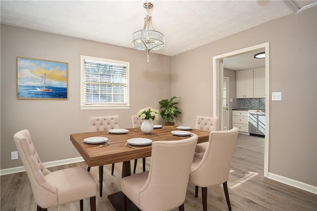 1312 La Mesa Dr, Lawrenceville, GA 30043 - dining space with baseboards, light wood-type flooring, a chandelier, and a textured ceiling