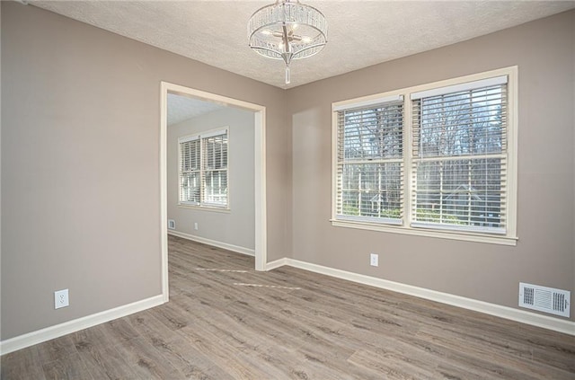 1312 La Mesa Dr, Lawrenceville, GA 30043 - unfurnished room featuring a chandelier, a textured ceiling, baseboards, and healthy amount of natural light