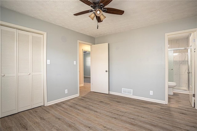 1312 La Mesa Dr, Lawrenceville, GA 30043 - unfurnished bedroom featuring baseboards, wood finished floors, a textured ceiling, and a closet