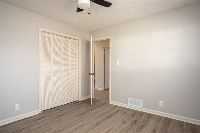1312 La Mesa Dr, Lawrenceville, GA 30043 - unfurnished bedroom with wood finished floors, baseboards, a textured ceiling, a closet, and ceiling fan