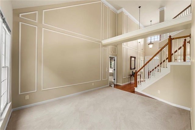 1995 Settindown Dr, Roswell, GA 30075 - carpeted entryway with stairs, a towering ceiling, and a decorative wall
