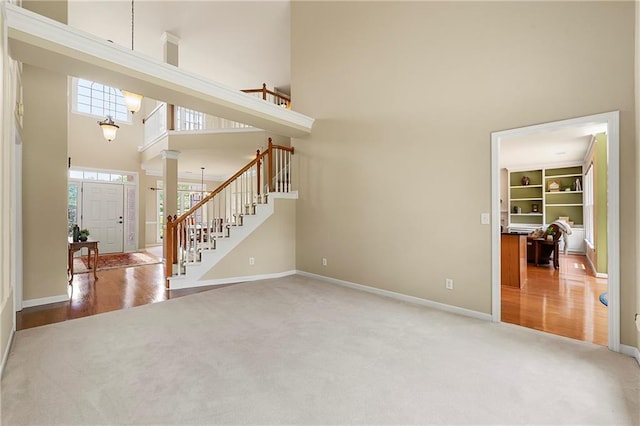 1995 Settindown Dr, Roswell, GA 30075 - unfurnished living room featuring a towering ceiling, carpet, stairway, and ornate columns