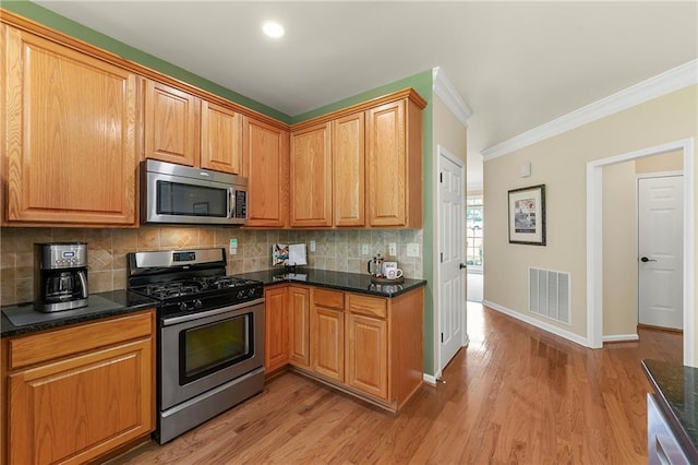 1995 Settindown Dr, Roswell, GA 30075 - kitchen with stainless steel appliances, crown molding, tasteful backsplash, light wood-type flooring, and dark stone countertops