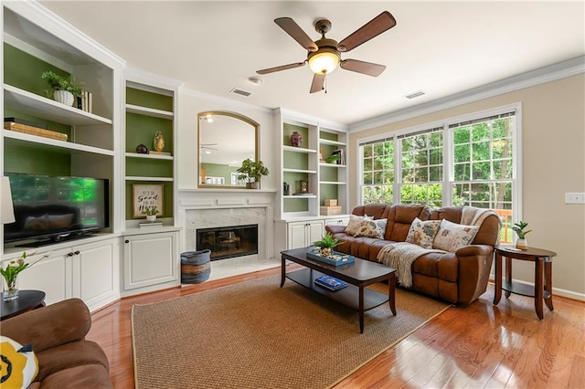 1995 Settindown Dr, Roswell, GA 30075 - living area with ornamental molding, ceiling fan, a fireplace, wood finished floors, and built in features