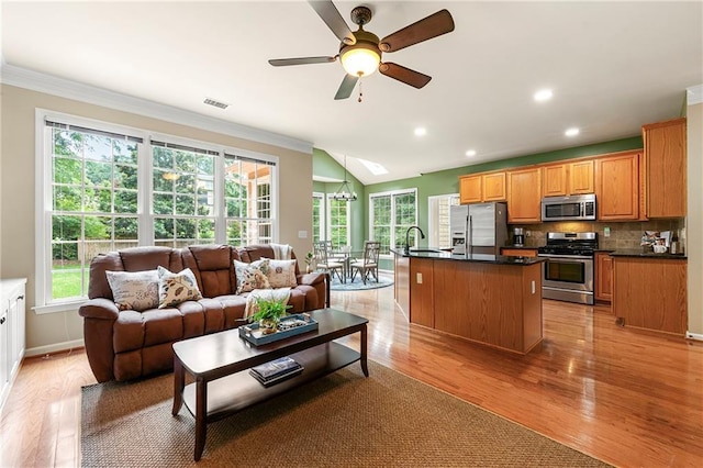 1995 Settindown Dr, Roswell, GA 30075 - kitchen featuring stainless steel appliances, dark countertops, open floor plan, ornamental molding, and plenty of natural light