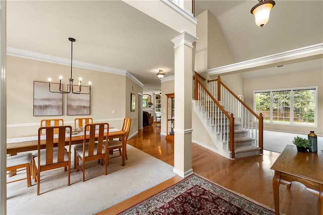 1995 Settindown Dr, Roswell, GA 30075 - dining area with wood finished floors, a chandelier, ornate columns, stairway, and ornamental molding