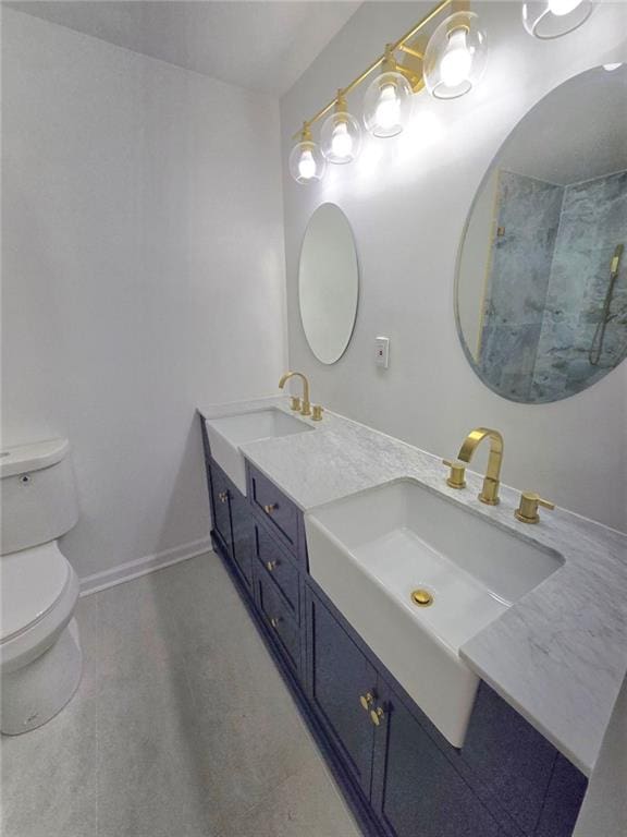 bathroom featuring baseboards, a sink, toilet, and double vanity