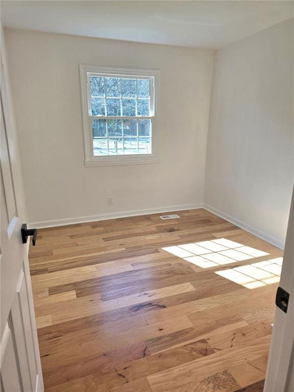 empty room featuring baseboards and wood finished floors