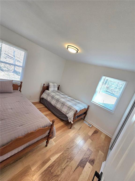 bedroom featuring light wood-style floors, baseboards, and visible vents