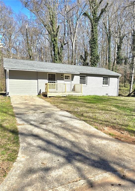 single story home with concrete driveway, brick siding, and a front yard
