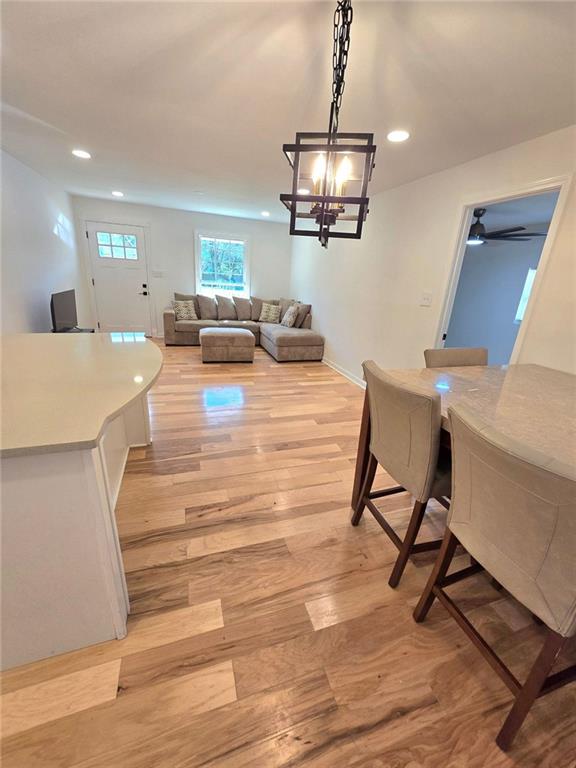 dining space with light wood finished floors and recessed lighting