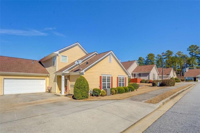 view of front of home with driveway, an attached garage, and a residential view