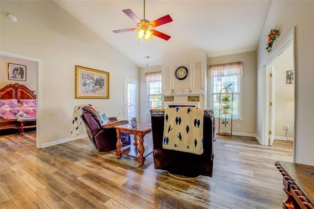 living area featuring ceiling fan, vaulted ceiling, baseboards, and wood finished floors