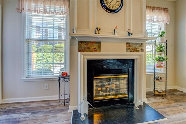 interior details with a fireplace, baseboards, and wood finished floors