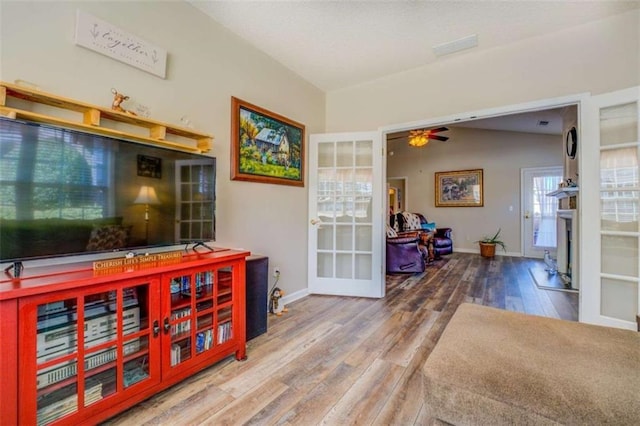 bar featuring a fireplace, lofted ceiling, ceiling fan, wood finished floors, and baseboards