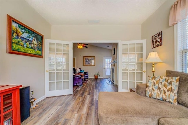 sitting room with french doors, ceiling fan, vaulted ceiling, wood finished floors, and baseboards