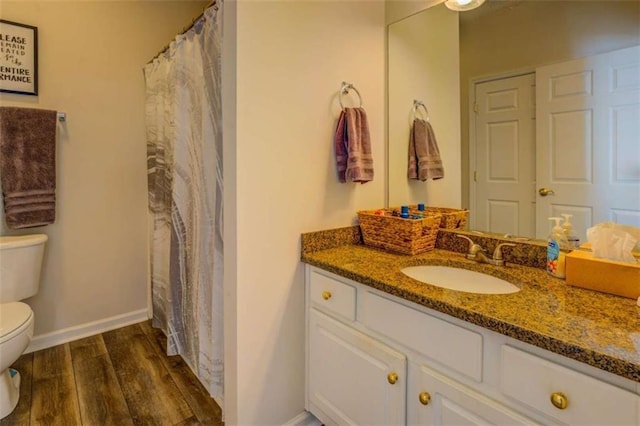 full bath featuring wood finished floors, vanity, toilet, and baseboards