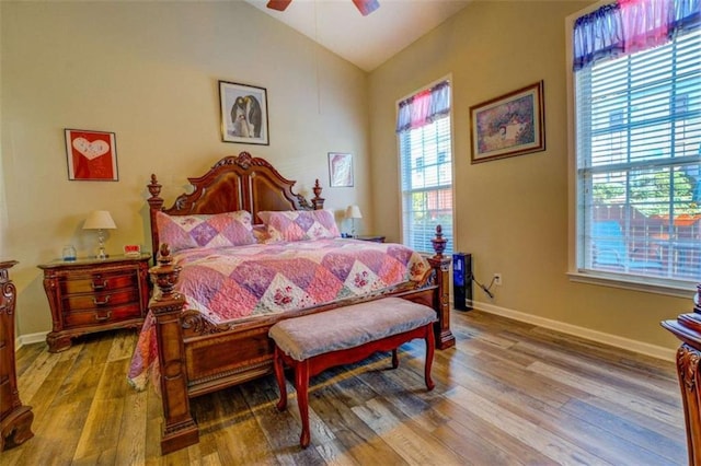 bedroom featuring lofted ceiling, a ceiling fan, baseboards, and wood finished floors