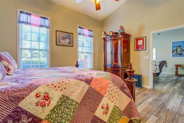 bedroom with vaulted ceiling, ceiling fan, light wood-type flooring, and baseboards