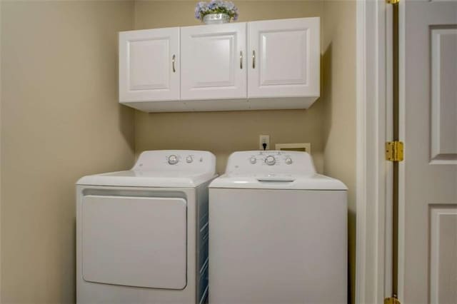 washroom featuring washing machine and dryer and cabinet space