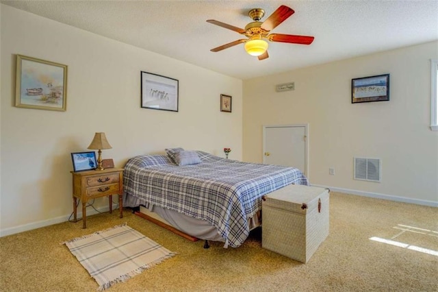 carpeted bedroom with visible vents, ceiling fan, and baseboards