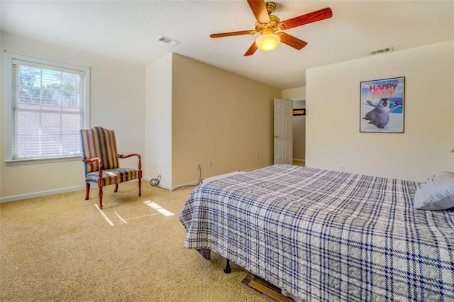 carpeted bedroom with visible vents, ceiling fan, and baseboards