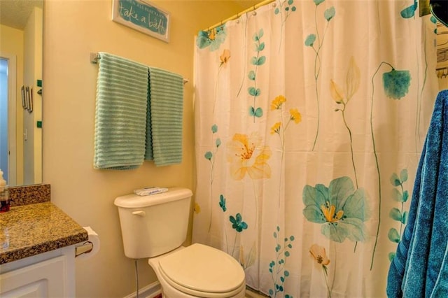 bathroom with toilet, a shower with curtain, baseboards, and vanity