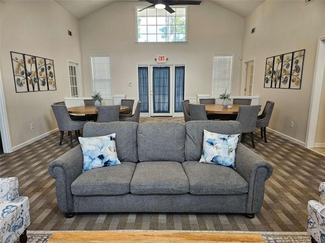 living room with ceiling fan, high vaulted ceiling, and baseboards