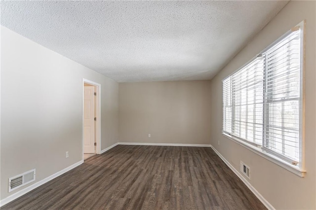 unfurnished room featuring dark hardwood / wood-style floors and a textured ceiling