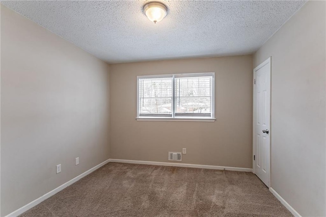 carpeted empty room with a textured ceiling