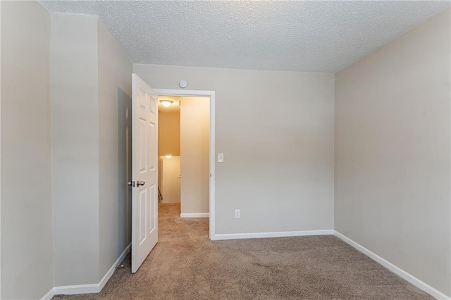 carpeted spare room featuring a textured ceiling