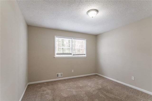 unfurnished room with carpet and a textured ceiling