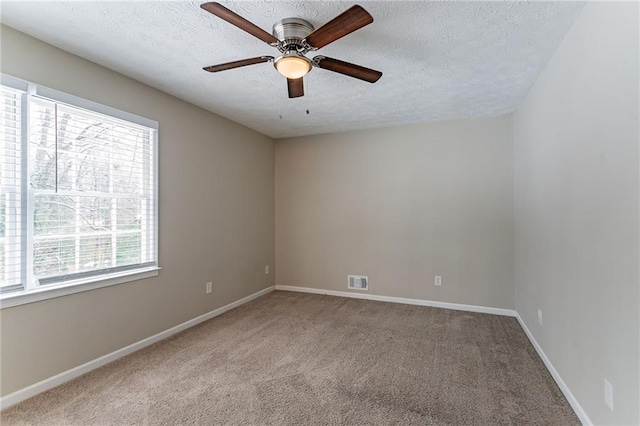 unfurnished room with ceiling fan, light colored carpet, and a textured ceiling