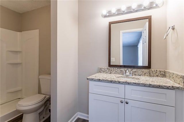 bathroom featuring walk in shower, vanity, and toilet