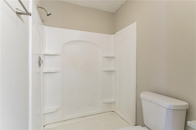 bathroom with a shower, a textured ceiling, and toilet