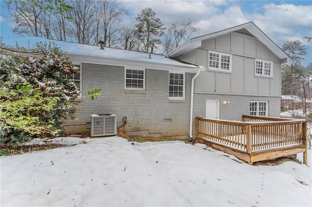 snow covered rear of property featuring central air condition unit and a deck