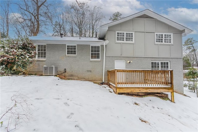 snow covered back of property featuring a wooden deck and central AC