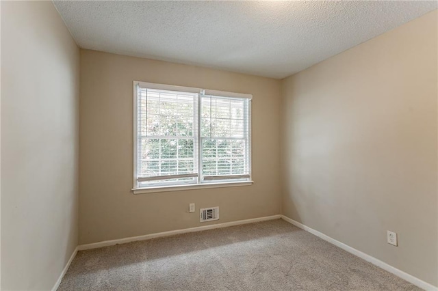 carpeted empty room with a textured ceiling