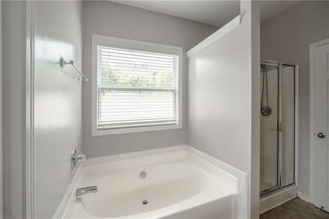 bathroom featuring shower with separate bathtub