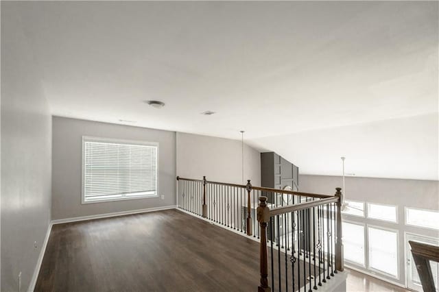 interior space with vaulted ceiling and dark hardwood / wood-style floors